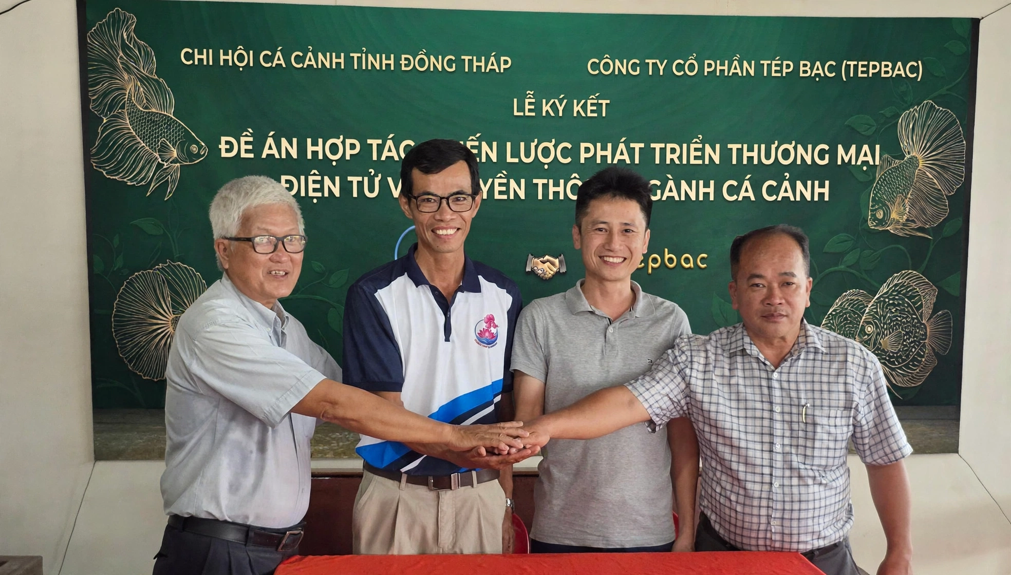 Bốn đại diện đặt tay hợp tác tại lễ ký kết giữa Chi hội Cá cảnh Đồng Tháp và Công ty Tép Bạc.