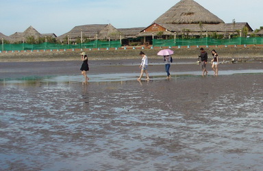 Du khách thích thú chạy chân trần trên bãi cát đen.