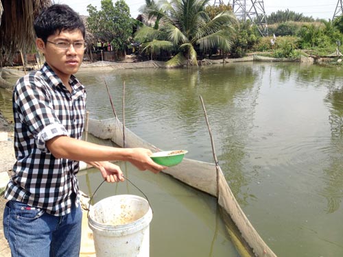 Huỳnh Tấn Đạt bên ao cá của mình - Ảnh: Lê Thanh