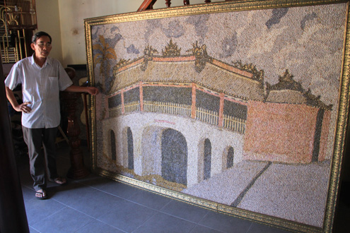 Ông Lữ Ngọc Năm với bức tranh ốc về chùa Cầu (Hội An) được trả giá 40 triệu đồng, nhưng vợ chồng ông quyết giữ lại làm kỷ niềm. Ảnh: Nguyễn Đông