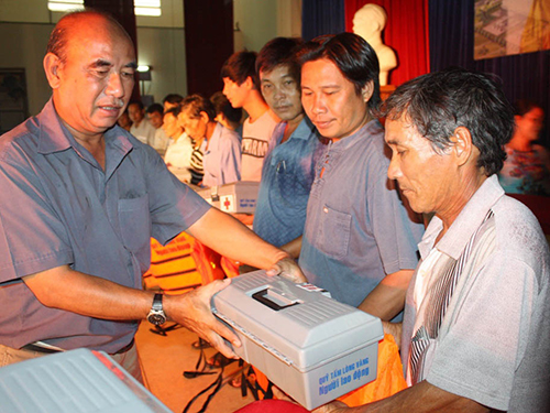 Đại diện Báo Người Lao Động (bìa trái) trao áo phao, tủ thuốc cho ngư dân