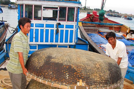 Ngư dân Dương Thành Vinh (bên trái) và Lê Văn Lộc trên chiếc tàu được đóng từ một phần kinh phí của Quỹ TLVLĐ.