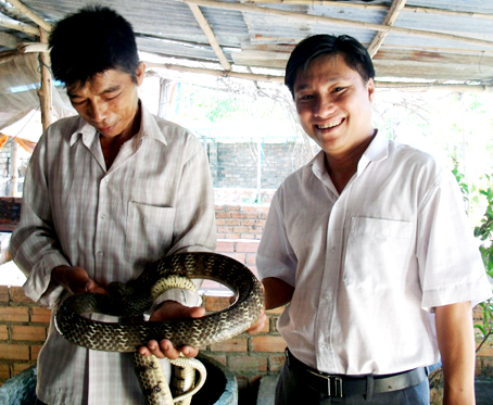 Anh Trần Dũng giới thiệu mô hình nuôi cá - ếch - rắn. Ảnh: B.NGUYÊN